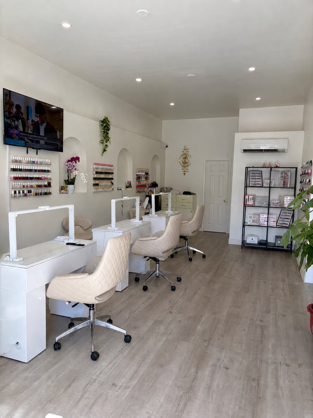 Modern Nails LA salon interior with modern workstations and polish wall display
